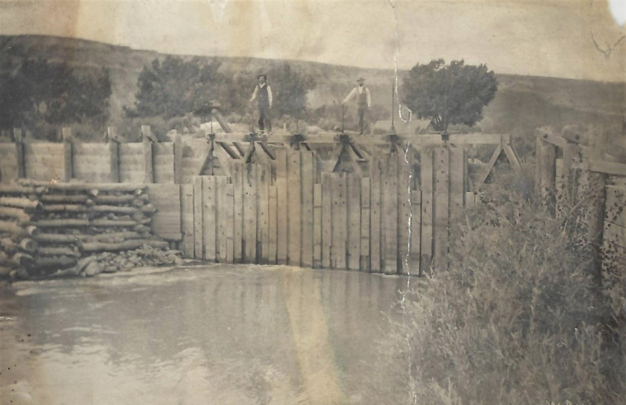 men standing on top of a headgate with the river below in 1883